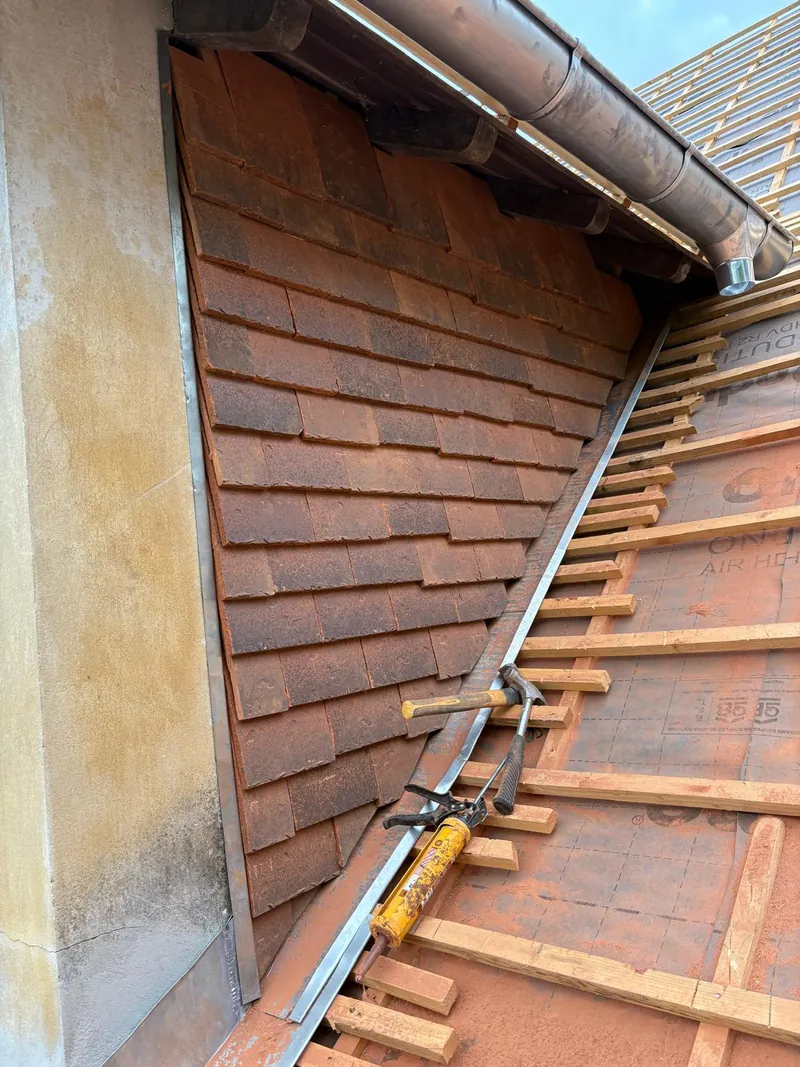 Détail d'outils de couvreur sur une toiture en tuiles